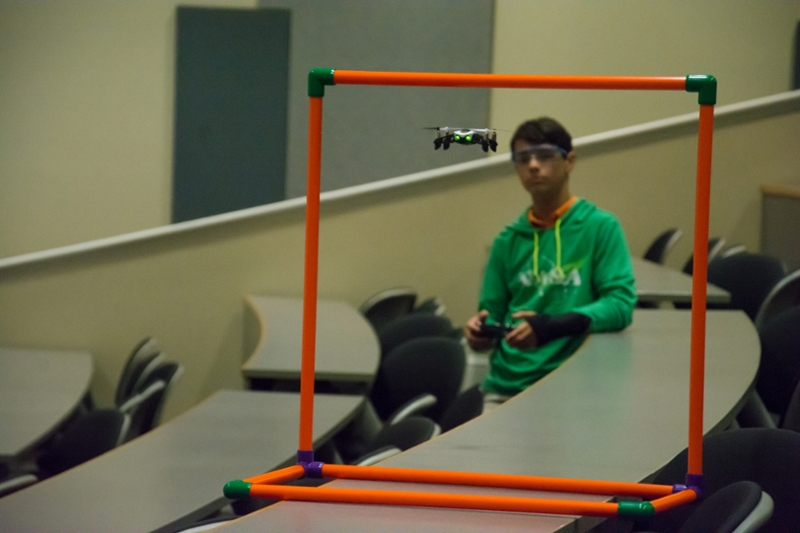 A student controlling a drone through an obstacle course. 